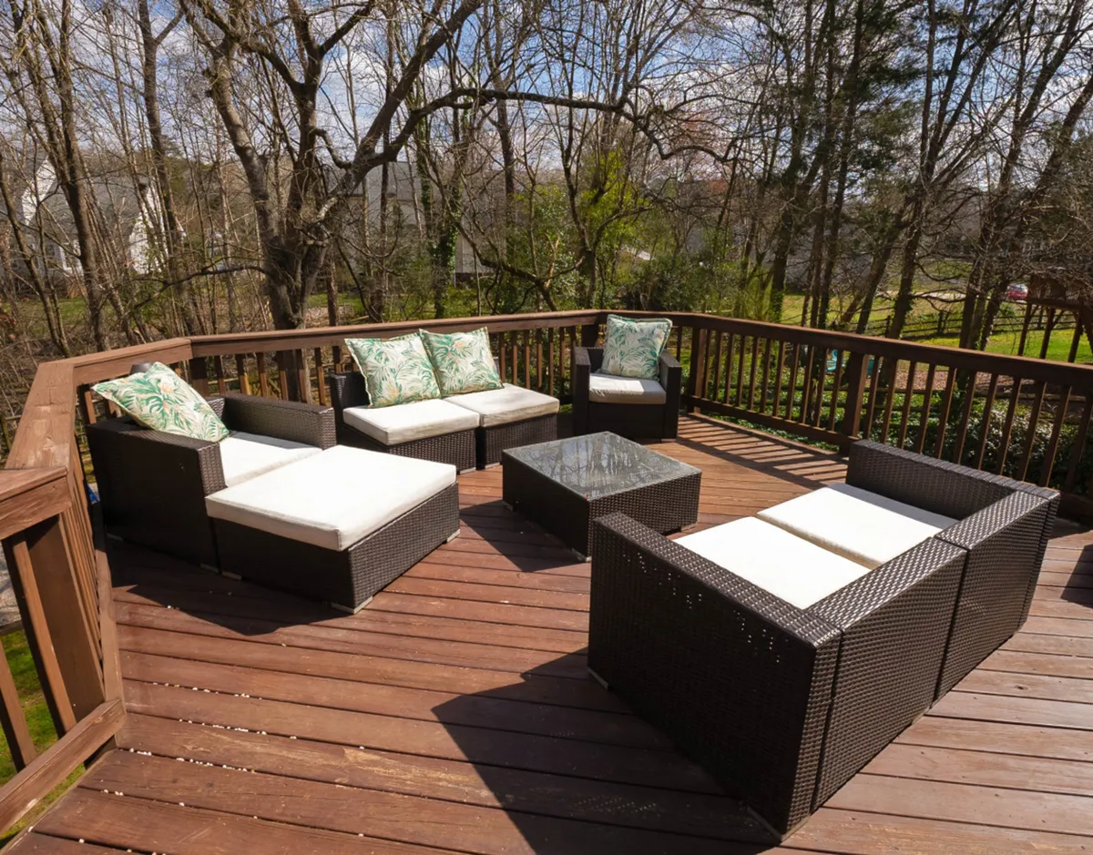 A relaxed outdoor seating area with decorative cushions and a glass coffee table, perfect for social gatherings. The scene is set for sunset views, stargazing, or morning sunbathing, evoking group activities and shared moments.